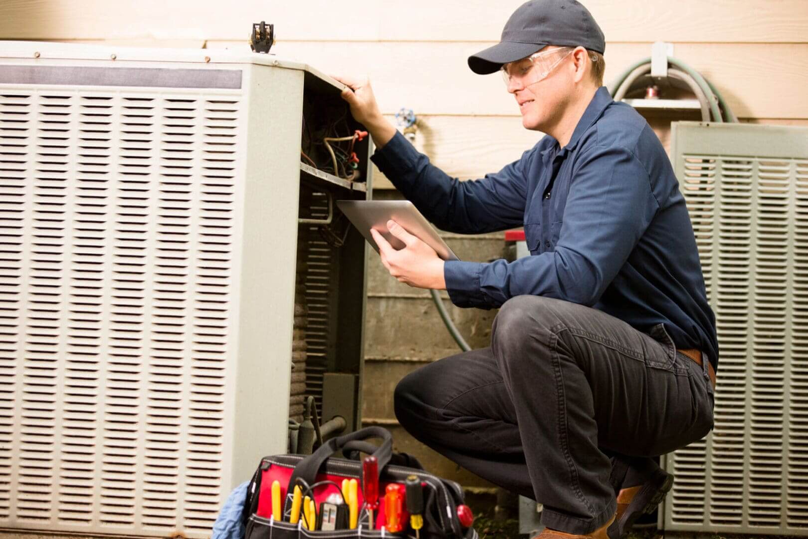 Technician inspecting HVAC unit with tools.
